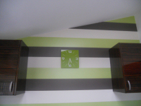 Green and White Wallpapered Wall with a Clock